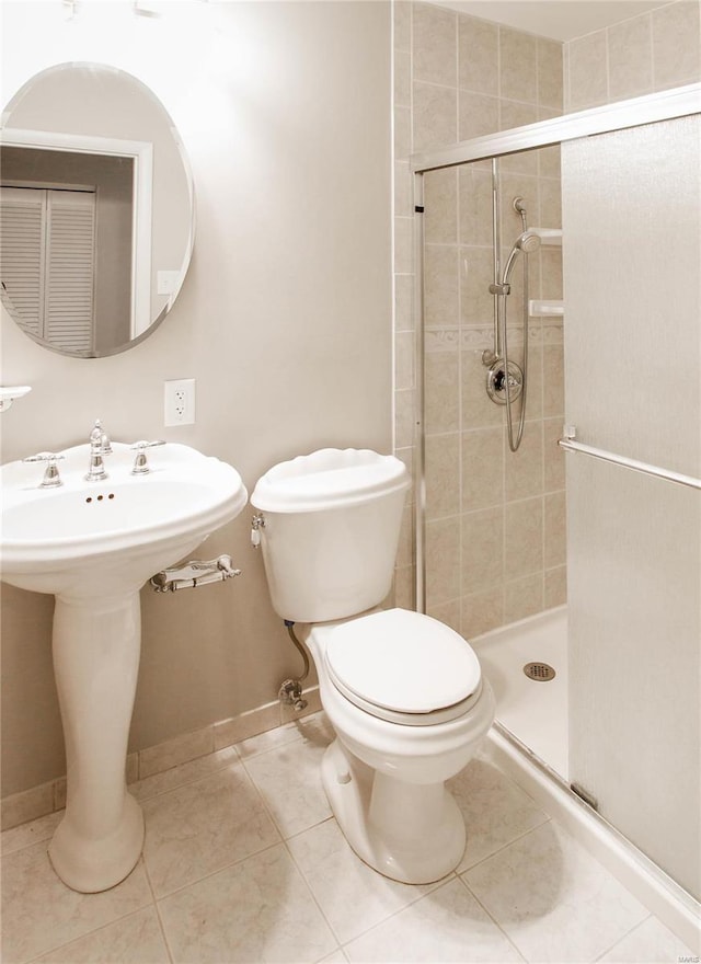 bathroom with tile patterned flooring, toilet, and a shower with door