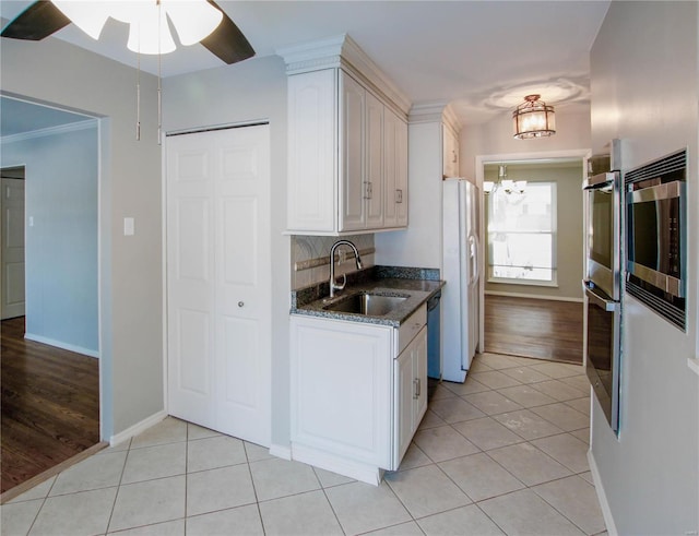 kitchen featuring appliances with stainless steel finishes, light tile patterned floors, a notable chandelier, and sink