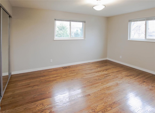 unfurnished bedroom featuring wood-type flooring and a closet