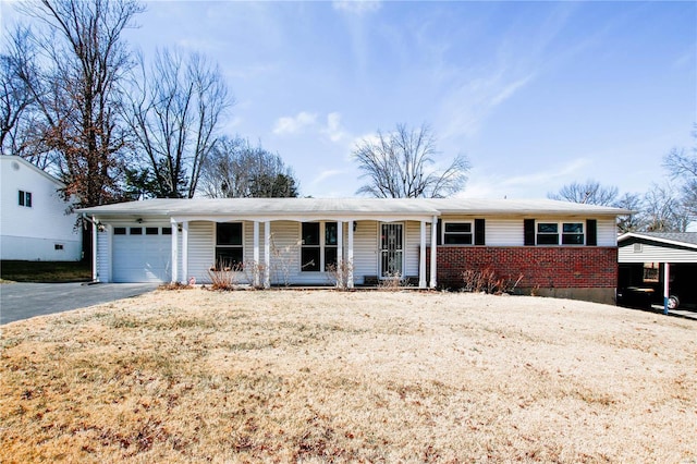 single story home featuring an attached garage, aphalt driveway, a porch, and brick siding