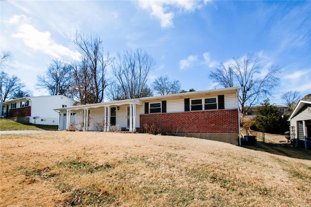 single story home with a porch, a front lawn, central AC, and brick siding