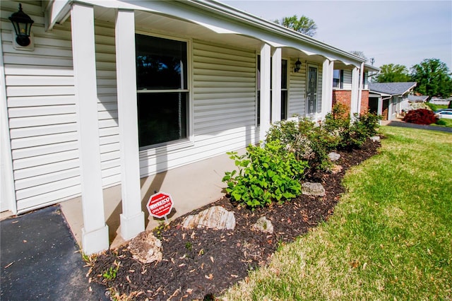 view of side of home with a porch and a yard