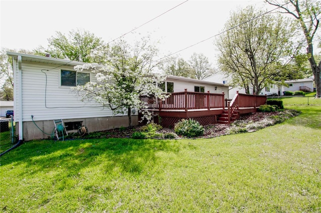 rear view of property featuring fence, a yard, and a deck