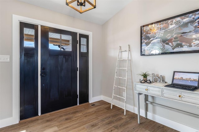 foyer entrance featuring wood finished floors and baseboards