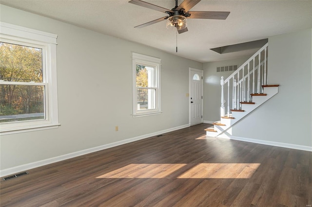 foyer entrance with dark wood-type flooring, a textured ceiling, and ceiling fan