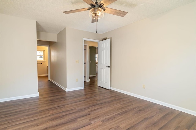 empty room with a textured ceiling, dark hardwood / wood-style floors, and ceiling fan