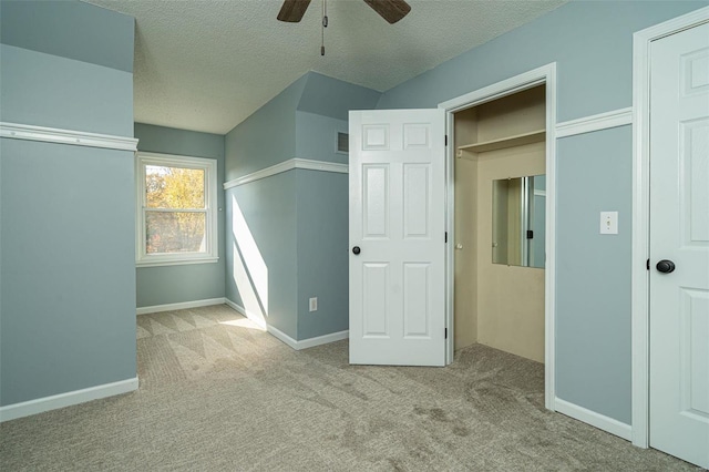 unfurnished bedroom featuring a textured ceiling, light colored carpet, and ceiling fan