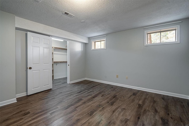 basement featuring dark hardwood / wood-style floors and a textured ceiling