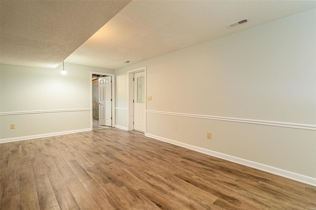 unfurnished room with wood-type flooring and a textured ceiling