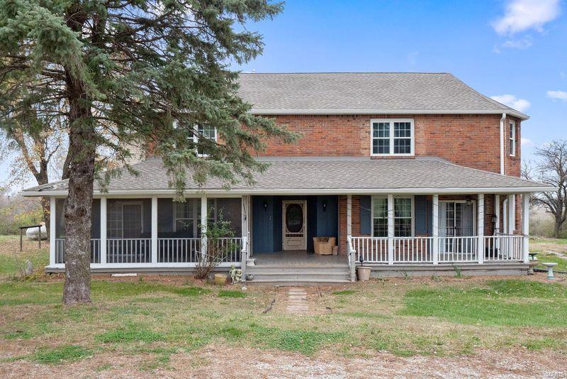 farmhouse featuring a porch and a front yard