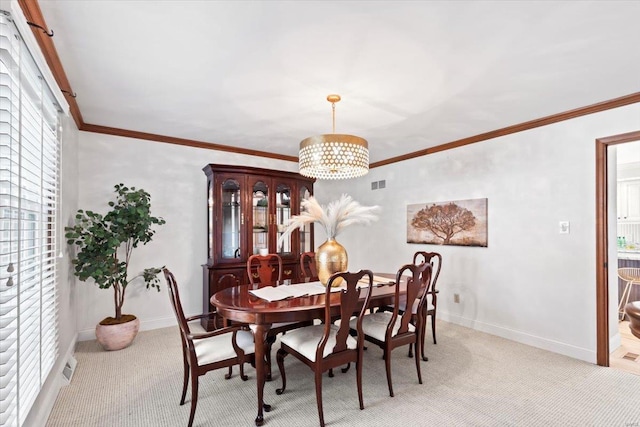 carpeted dining room with a notable chandelier and ornamental molding