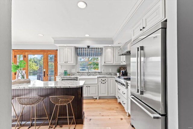 kitchen featuring white cabinetry, a healthy amount of sunlight, appliances with stainless steel finishes, and a breakfast bar