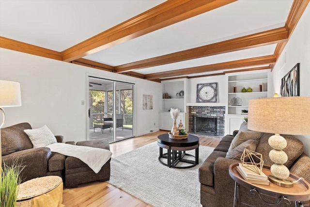 living room with beamed ceiling, light hardwood / wood-style flooring, and a fireplace