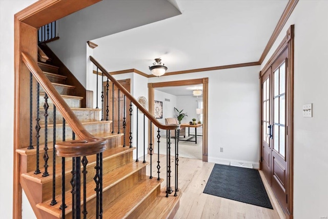 foyer entrance featuring ornamental molding and light wood-type flooring