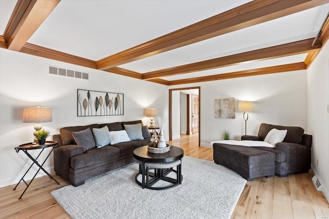 living room featuring beamed ceiling and light hardwood / wood-style flooring