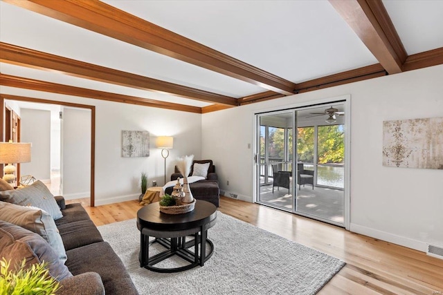 living room featuring light hardwood / wood-style flooring, beamed ceiling, and ceiling fan