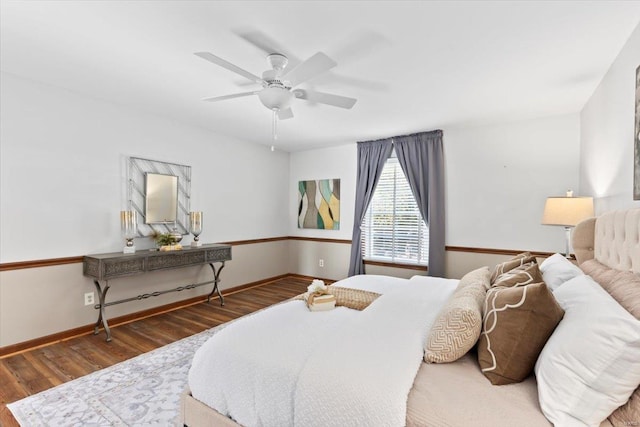 bedroom with dark hardwood / wood-style flooring and ceiling fan