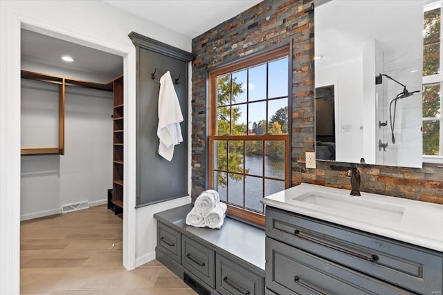 bathroom featuring vanity, tasteful backsplash, wood-type flooring, and walk in shower