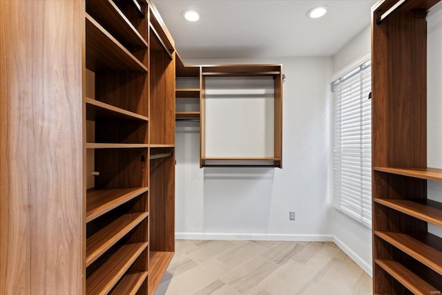 walk in closet with light hardwood / wood-style floors