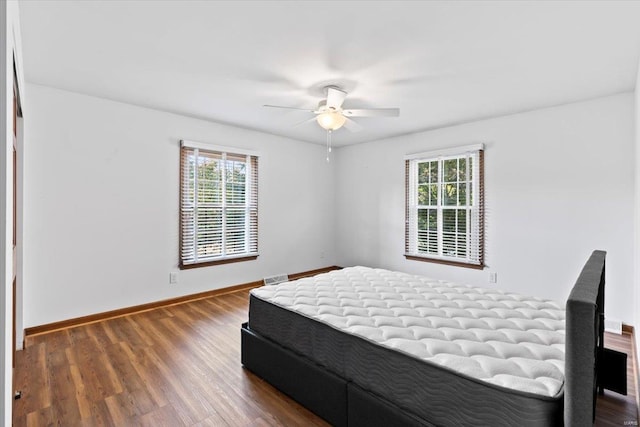 bedroom with dark hardwood / wood-style floors and ceiling fan