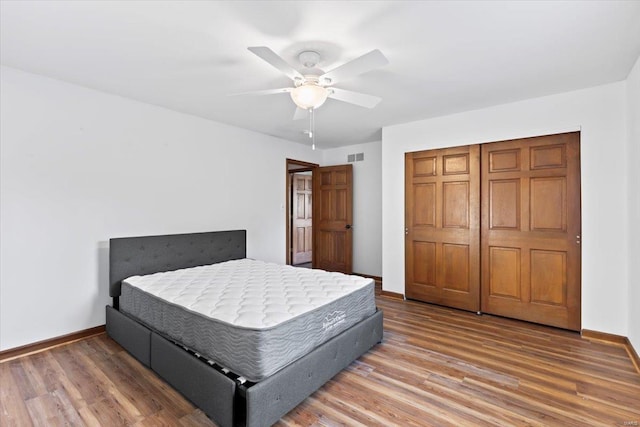 bedroom featuring a closet, ceiling fan, and dark hardwood / wood-style flooring