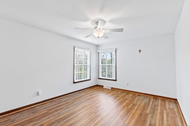 empty room with ceiling fan and hardwood / wood-style floors