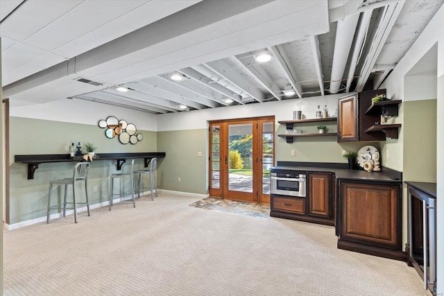 bar with light colored carpet, beverage cooler, and stainless steel oven