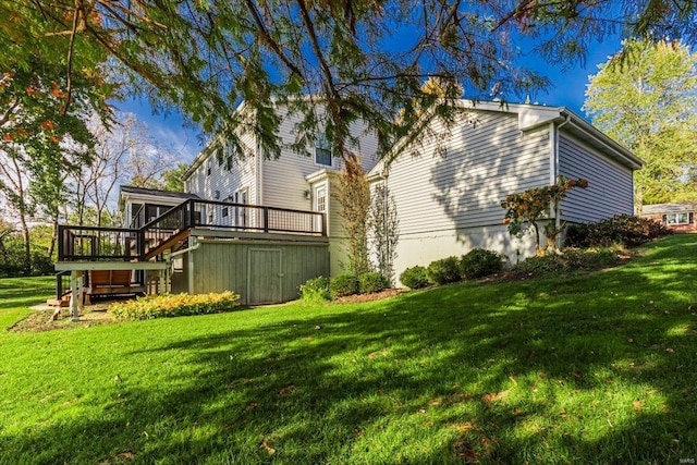 rear view of property featuring a wooden deck and a yard