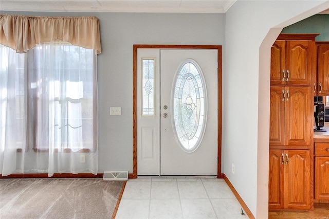 tiled foyer entrance with ornamental molding