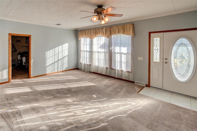 carpeted foyer entrance featuring a textured ceiling and ceiling fan