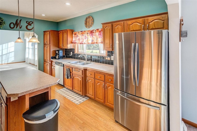 kitchen featuring stainless steel appliances, backsplash, sink, pendant lighting, and light wood-type flooring