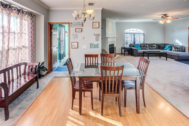 dining area featuring crown molding, a textured ceiling, ceiling fan with notable chandelier, and hardwood / wood-style floors