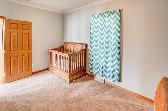 bedroom featuring crown molding, carpet, and a crib