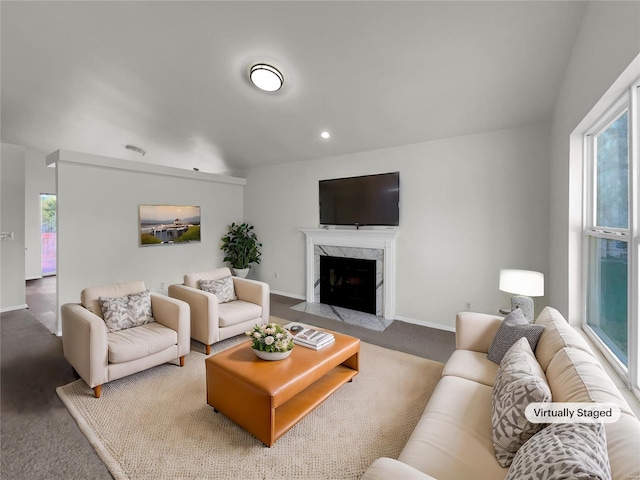 living room featuring a high end fireplace and carpet floors