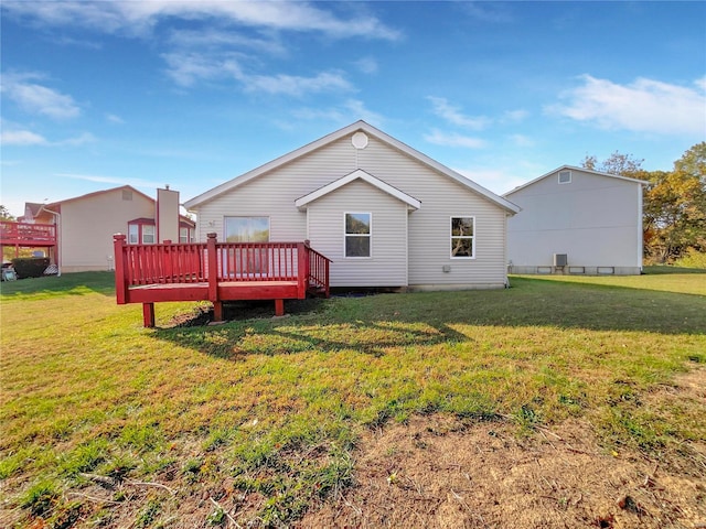 rear view of house featuring a wooden deck and a yard