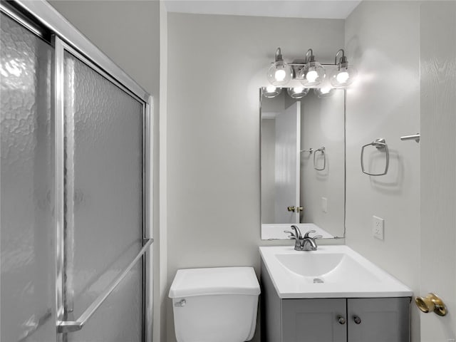 bathroom featuring vanity, toilet, and an enclosed shower