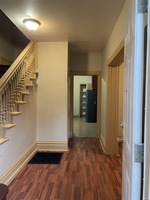 corridor featuring dark wood-type flooring and a textured ceiling