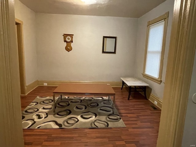 sitting room with dark wood-type flooring and plenty of natural light