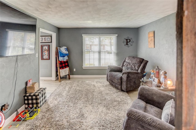 sitting room with a textured ceiling and light wood-type flooring