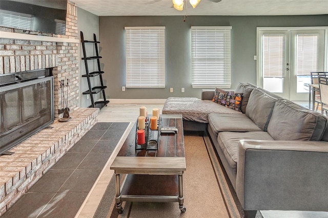 living room featuring french doors, ceiling fan, and a fireplace