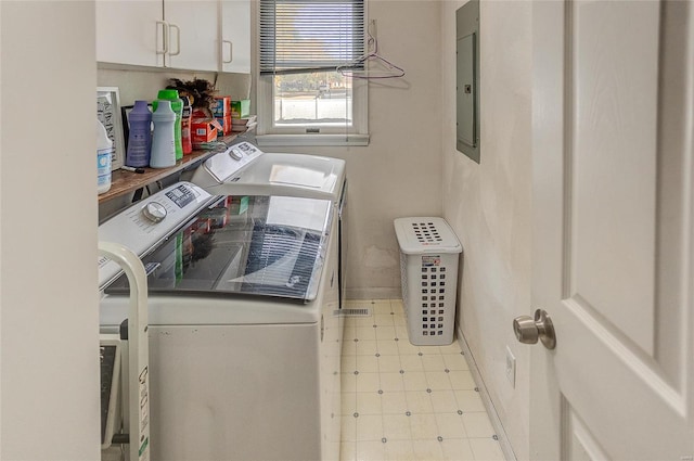 laundry room with electric panel, independent washer and dryer, and cabinets