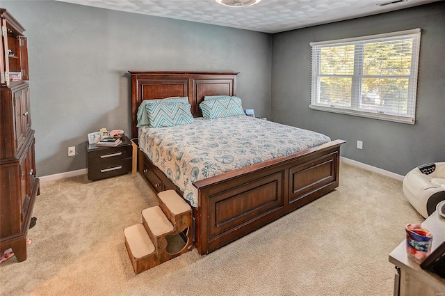 bedroom with light carpet and a textured ceiling