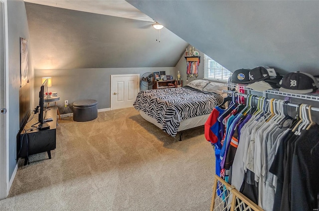 carpeted bedroom with vaulted ceiling and ceiling fan