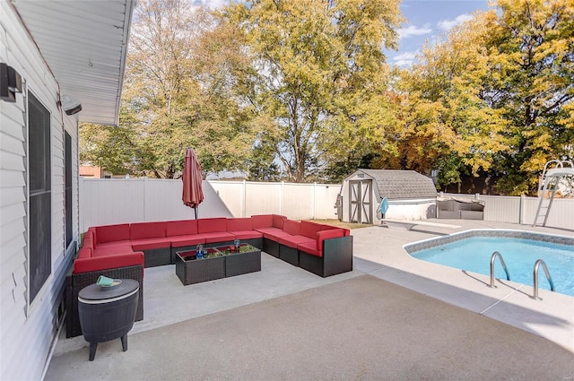 view of pool featuring a storage shed, an outdoor living space, and a patio