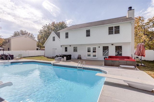 view of swimming pool with french doors, a patio area, and a diving board