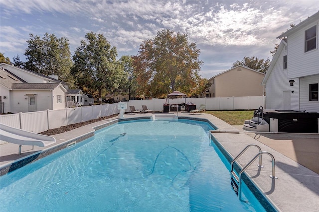 view of swimming pool featuring a water slide and a patio area