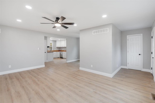 unfurnished room with ceiling fan, light hardwood / wood-style flooring, and sink