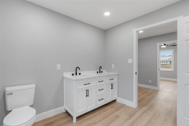 bathroom featuring hardwood / wood-style flooring, vanity, ceiling fan, and toilet