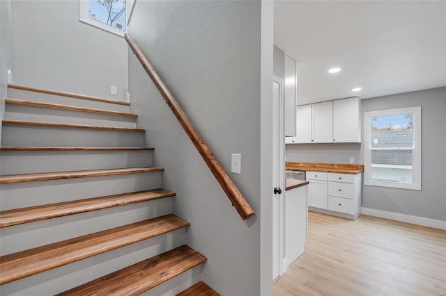 stairs featuring hardwood / wood-style floors and built in desk