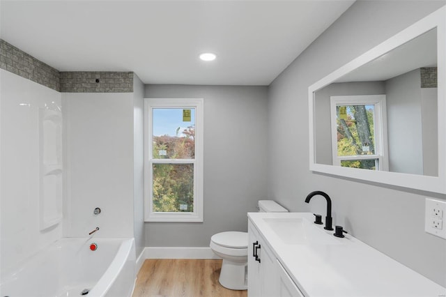 full bathroom with hardwood / wood-style floors, vanity, toilet, and a wealth of natural light